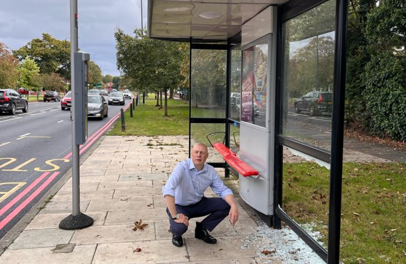 Jonathan Hulley next to vandalised bus stop on the Chertsey Road