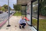 Jonathan Hulley next to vandalised bus stop on the Chertsey Road
