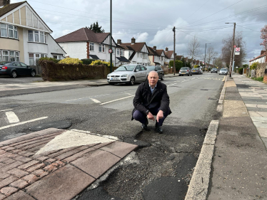 Jonathan Hulley by dangerous pothole on Powder Mill Lane in Whitton